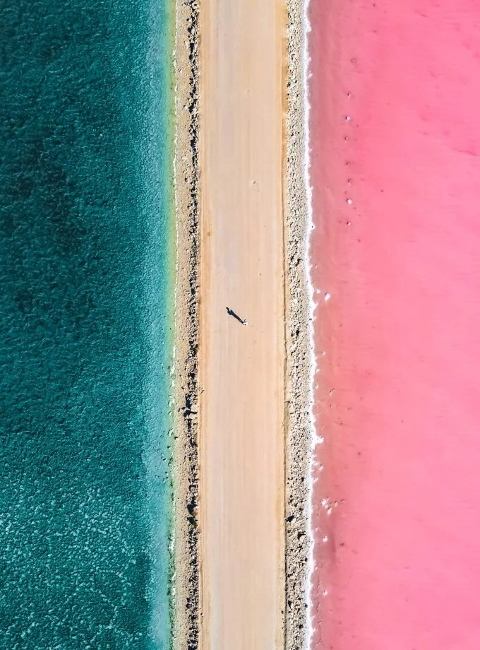 Aerial drone photography of Lake MacDonnell showing its pink hues and the blue sea.